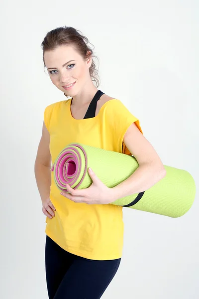 Portrait of beautiful young woman with gym mat — Stock Photo, Image