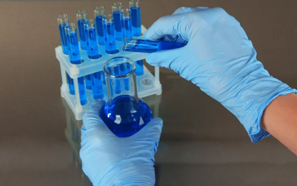 Cientista trabalhando em laboratório em fundo cinza — Fotografia de Stock