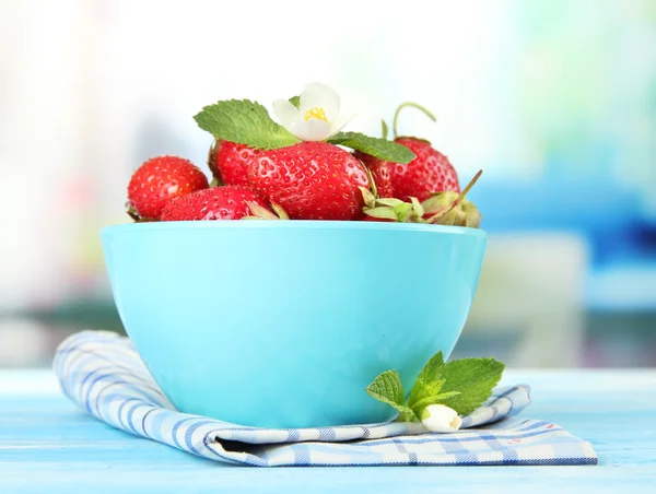 Rijpe zoete aardbeien in kom op blauwe houten tafel — Stockfoto