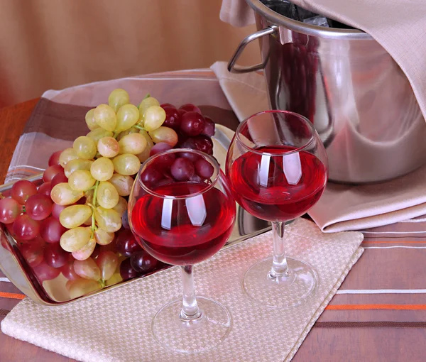 Vigne et verres sur table ronde sur fond de tissu — Photo