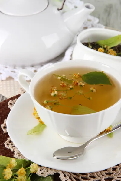 Tasse Tee mit Linden auf Servietten auf Holztisch — Stockfoto