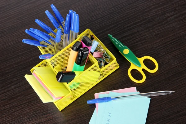 Office equipment in yellow stationary holder on dark wooden table — Stock Photo, Image