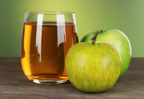 Glas färsk äppeljuice på bordet på grön bakgrund — Stockfoto