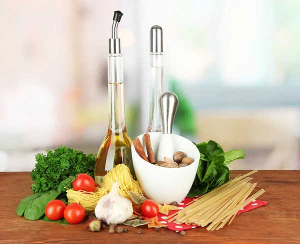 Composition of mortar, pasta and green herbals, on bright background — Stock Photo, Image