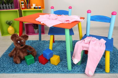 küçük ve renkli masa ve sandalyeler ile bebek giysileri