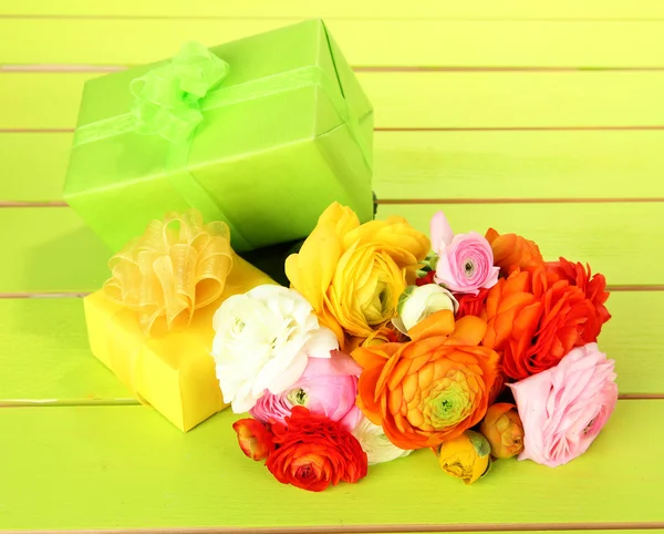 Düğünçiçeği (Farsça düğünçiçekleri) ve hediyeler, yeşil ahşap zemin üzerinde — Stok fotoğraf