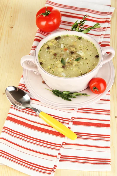 Nourishing soup in pink pan on wooden table close-up — Stock Photo, Image