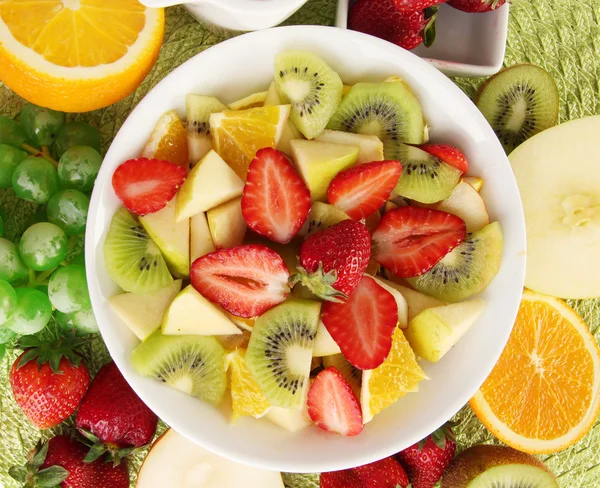 Salad buah yang berguna dari buah-buahan segar dan buah beri dalam mangkuk di atas serbet yang diisolasi di atas putih — Stok Foto