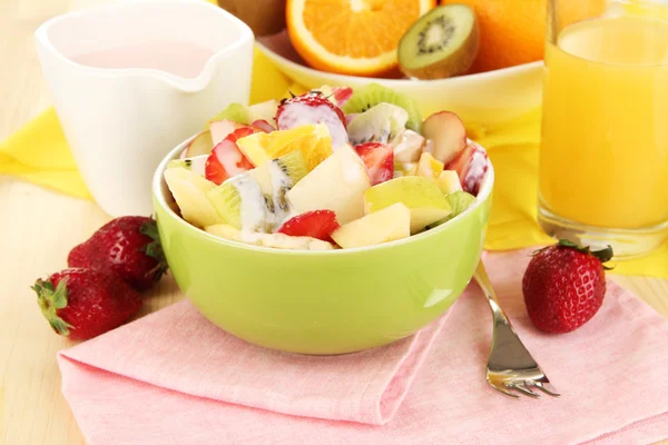 La ensalada útil de frutas frescas y las bayas en la escudilla a la servilleta a la mesa de madera el primer plano — Foto de Stock