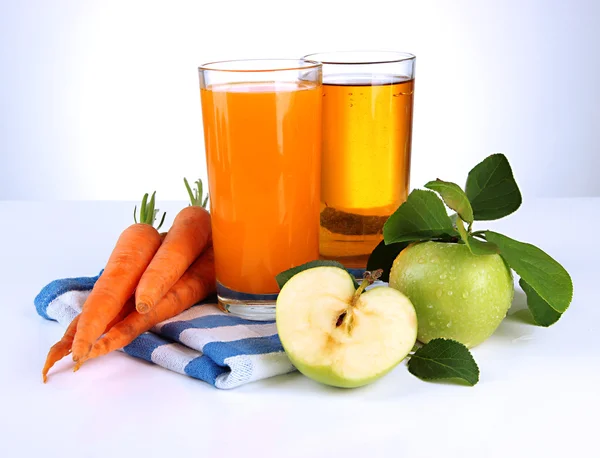 Glasses of juice, apples and carrots, isolated on white