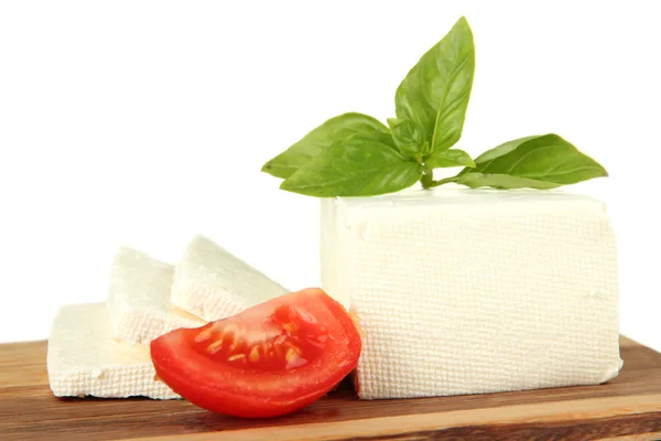 Sheep milk cheese with basil and tomato on cutting board, isolated on white — Stock Photo, Image