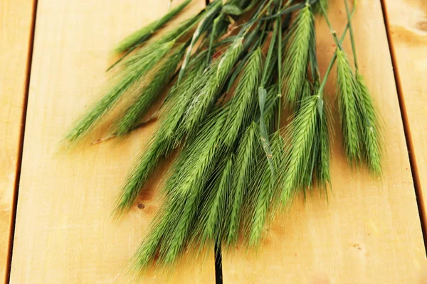 Muchas espiguillas sobre fondo de madera — Foto de Stock