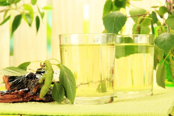 Glazen birch sap op groene houten tafel — Stockfoto