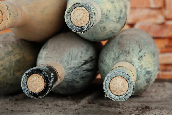 Gamla flaskor vin, på tegelstenar bakgrund — Stockfoto