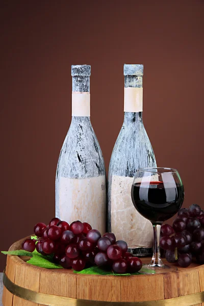 Samenstelling met oude fles wijn en wijnglas in oude kelder, op donkere bruine achtergrond — Stockfoto