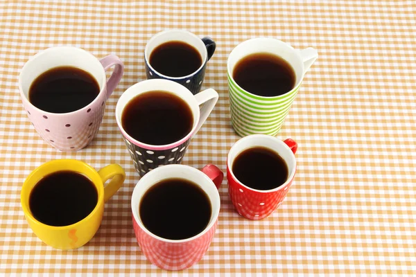 Molte tazze di caffè su tovagliolo a scacchi — Foto Stock