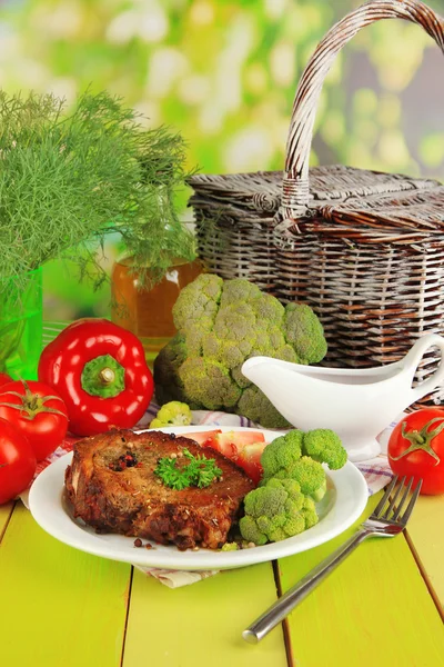 Trozo de carne frita en plato sobre mesa de madera sobre fondo natural —  Fotos de Stock