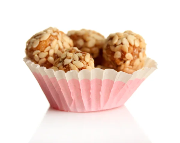 Cacahuetes sabrosos con sésamo y caramelo, aislados en blanco — Foto de Stock