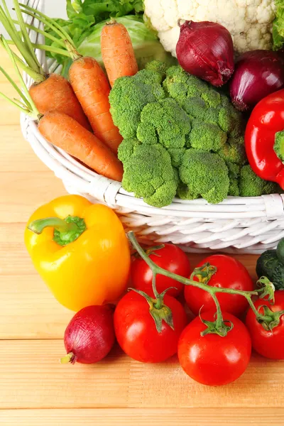 Verdure fresche in vimini bianco cestino su sfondo di legno — Foto Stock