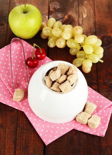 Unrefined sugar in white sugar bowl on wooden background — Stock Photo, Image