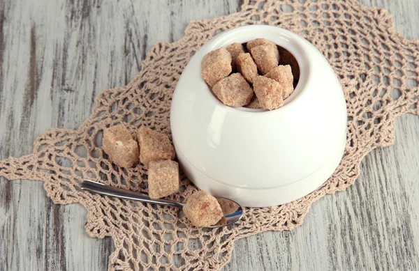 Unrefined sugar in white sugar bowl on wooden background — Stock Photo, Image