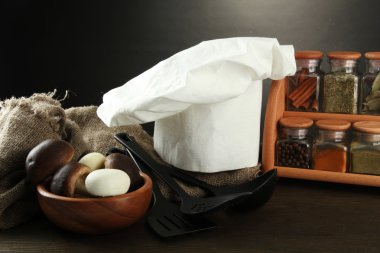 Şef'in şapkası ve kitchenwear tabloda gri arka plan üzerinde kompozisyonu