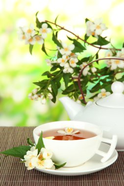 Yasemin, üzerinde parlak arka plan bambu hasır ile çay