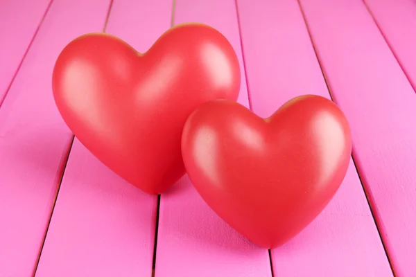 Decorative red hearts on color wooden background — Stock Photo, Image