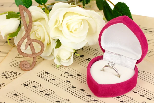 Clave triple, rosas y caja con anillo de boda sobre fondo musical —  Fotos de Stock