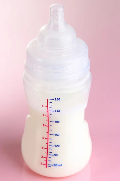 Fles voor melk formule op roze achtergrond — Stockfoto