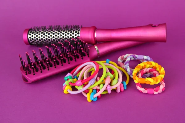 Scrunchies, escova de cabelo e cabelo - clipe em um fundo rosa — Fotografia de Stock