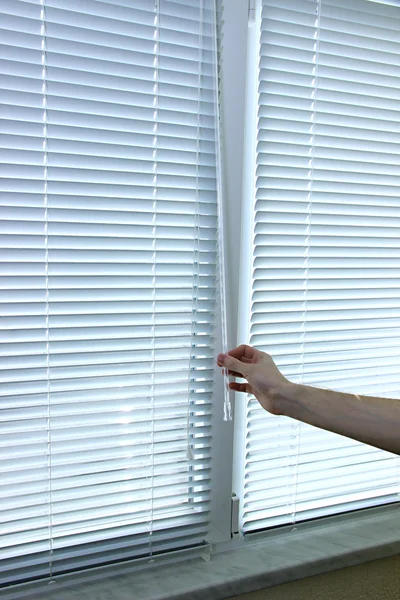 Someone opens blinds — Stock Photo, Image