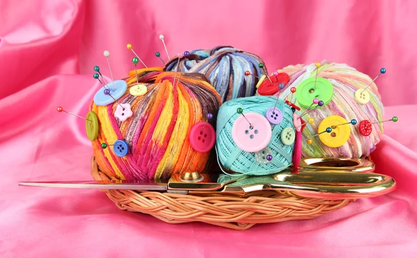 Colorful buttons and multicolor wool balls, on color fabric background — Stock Photo, Image