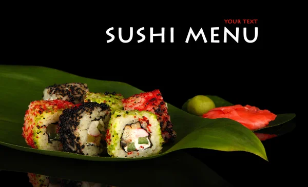 Sushi saporito su foglia verde su sfondo scuro — Foto Stock