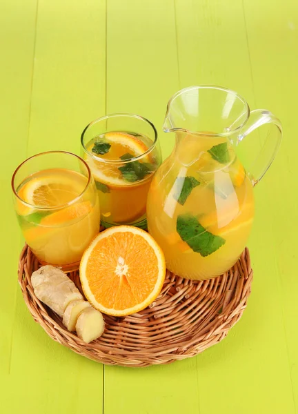 Апельсиновый лимонад в кувшине и стаканы на деревянном столе крупным планом — стоковое фото