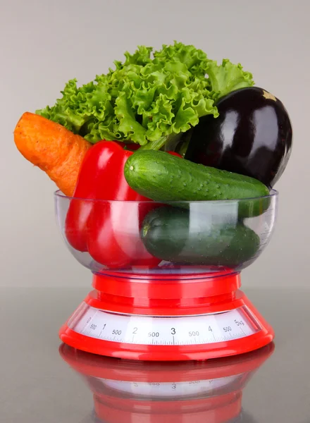 Свежие овощи в весах на сером фоне — стоковое фото