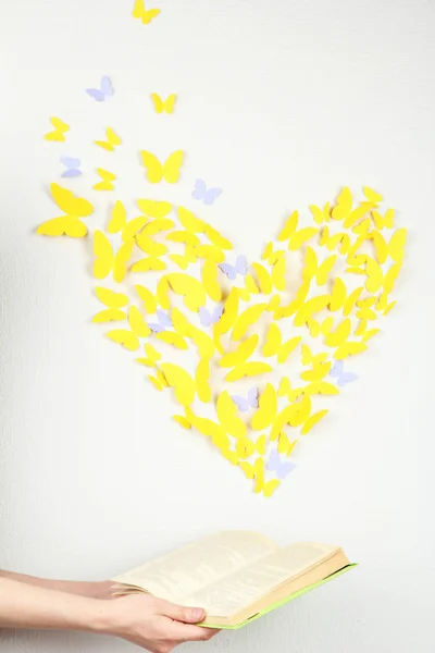 Papír žlutý motýl v podobě srdce fly z knihy — Stock fotografie
