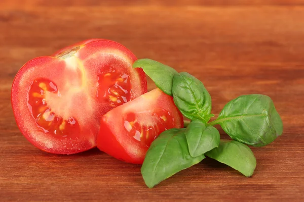 Tomato and basil on wooden background — Stock Photo, Image