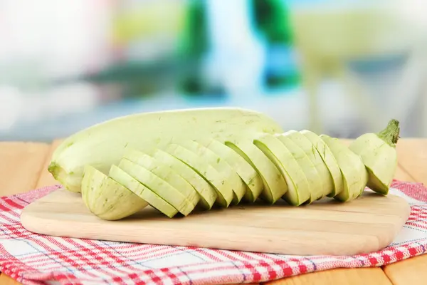 Fresh marrows on cutting board, on wooden table, on bright background — Stock Photo, Image