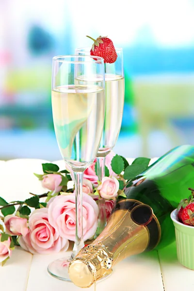 Romantische Stilleven met champagne, aardbei en roze rozen, op lichte achtergrond — Stockfoto