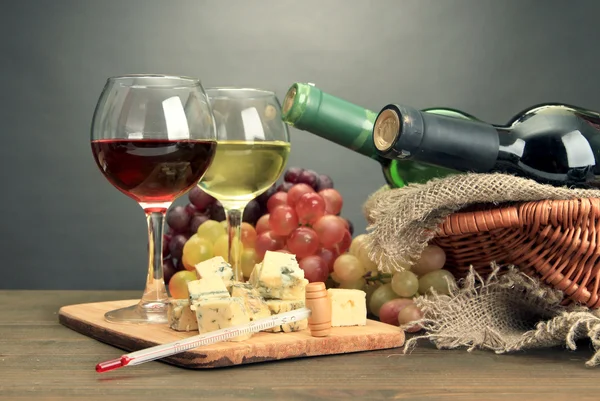 Komposition mit Wein, Blauschimmelkäse und Trauben auf Holztisch, auf grauem Hintergrund — Stockfoto