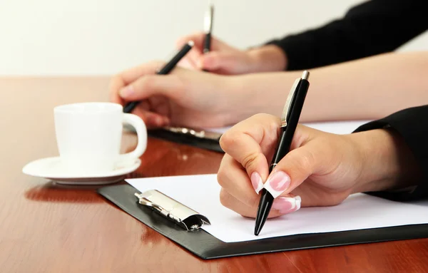 Primer plano de las manos de mujer de negocios con taza de café durante el trabajo en equipo — Foto de Stock