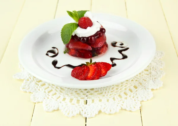 Смачний желе-десерт зі свіжими ягодами, на кольоровому дерев'яному фоні — стокове фото