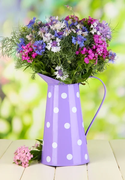 Beau bouquet en pichet sur table en bois sur fond naturel — Photo