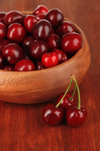 Cherry berries in bowl on wooden table close-up — Stock Photo, Image