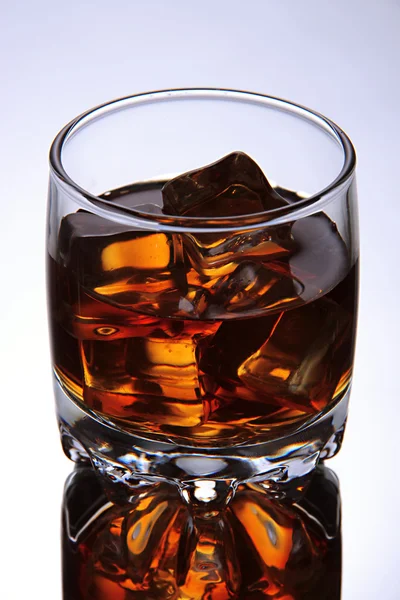 Brandy Glas mit Eis auf grauem Hintergrund — Stockfoto