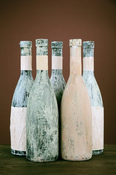 Garrafas velhas de vinho, em fundo marrom escuro — Fotografia de Stock