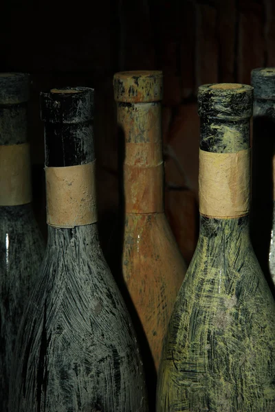 Vieilles bouteilles de vin dans une ancienne cave, sur fond sombre — Photo