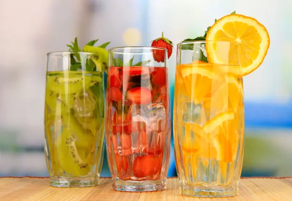 Vasos de bebidas de frutas con cubitos de hielo en la mesa en la cafetería —  Fotos de Stock