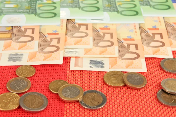 Billets en euros et cents en euros sur fond rouge — Photo